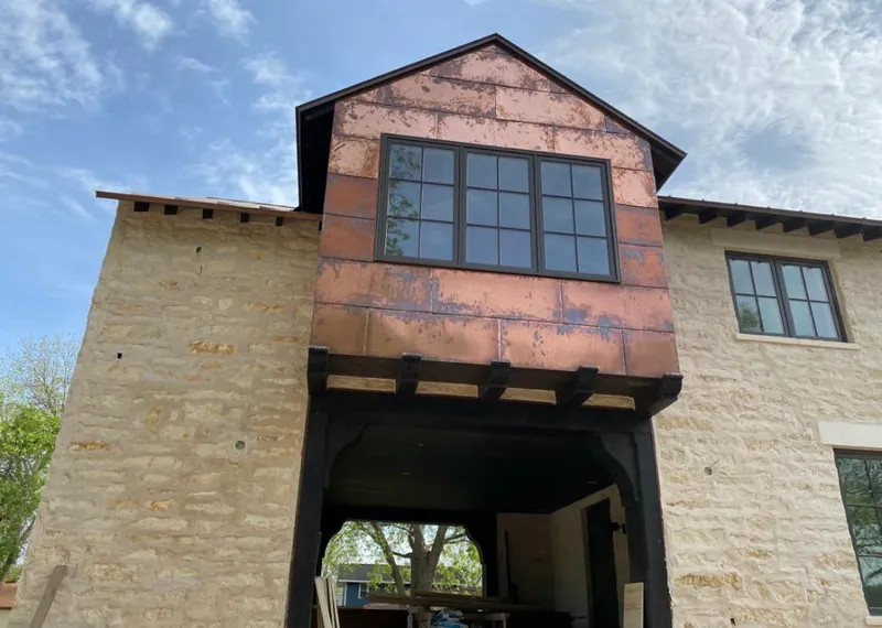 Copper metal panel facade on a stone building for Roof Repair in Olathe
